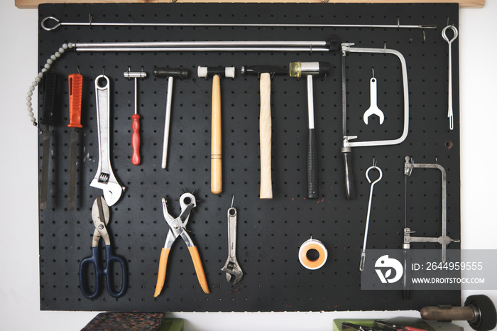 black pegboard with tooling on a white wall