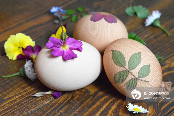 Naturally decorated Easter eggs with leaves and flowers prepared for dyeing with onion skins