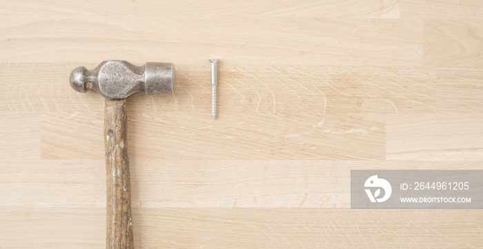 Old retro hammer and screw on wooden workbench