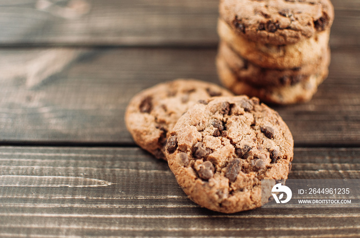 A stack of chocolate chip cookies lies on a wooden table. Rustic table. Vintage toning. Dietary useful cookies without gluten. Copy space.