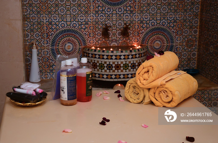 Bath bombs and moroccan clay powder, spa composition with brush and lit candles on white background.