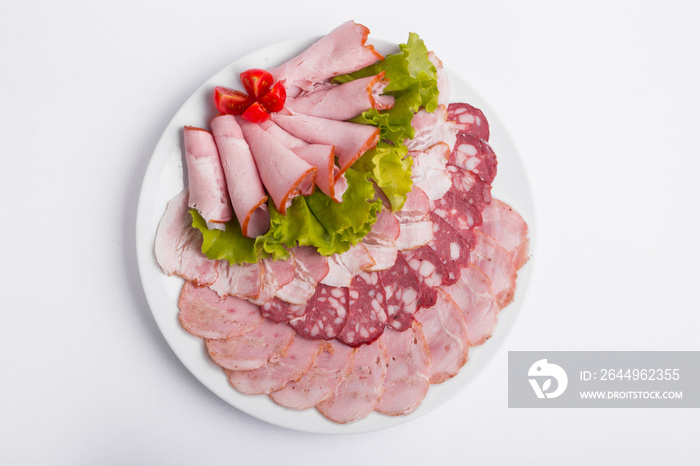 Food tray with delicious salami, pieces of sliced ham, sausage, tomatoes, salad and vegetable