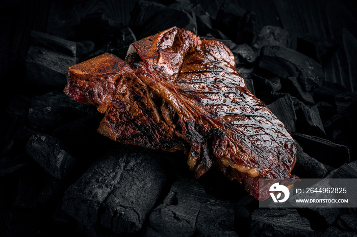 Grilling a tasty tender marinated t-bone steak on a coals.