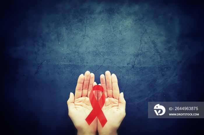 Symbol of human immunodeficiency virus disease. Red ribbon. A helping hand and support.