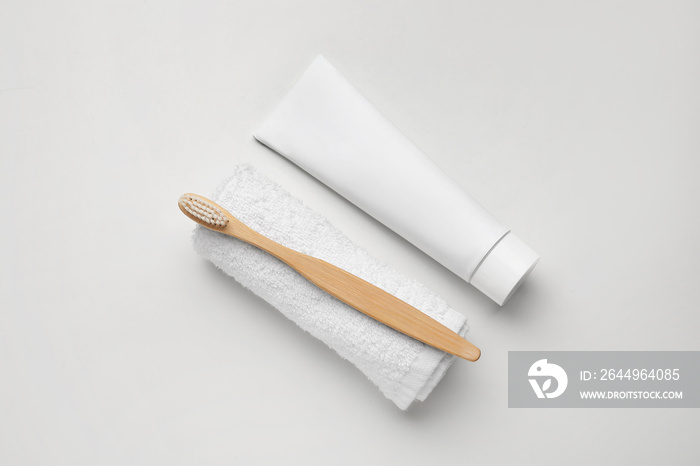 Tooth brush with paste and towel on white background