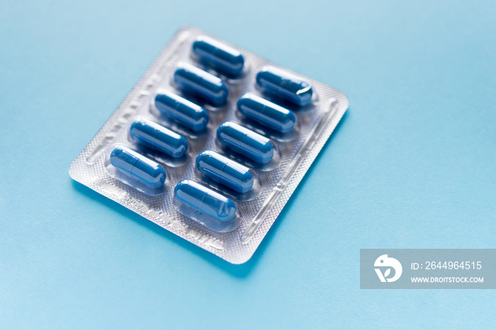 blister with pills, capsules of blue color on a blue background