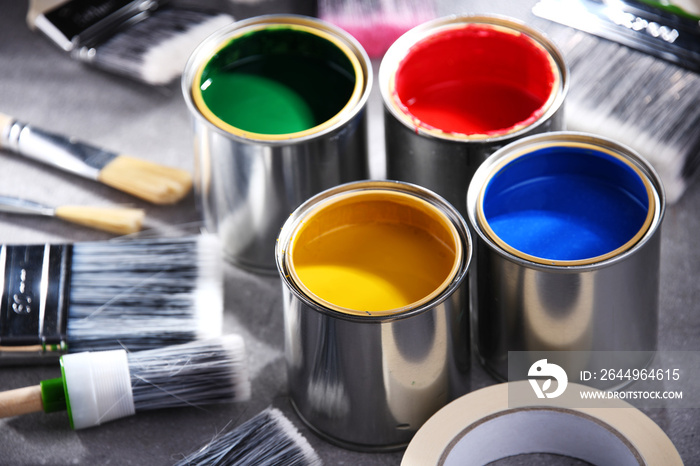 Paintbrushes of different size and paint cans