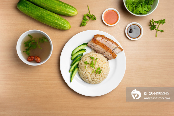 Roast Pork Rice with raw cucumber, Coriander, salad, sauce and soup served in a dish isolated on wooden background top view