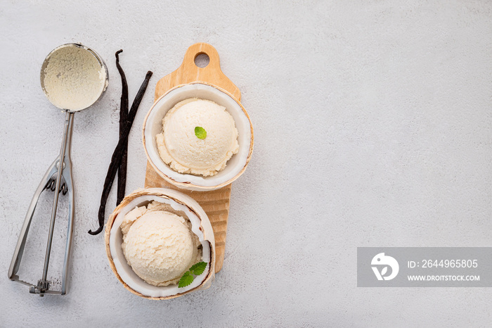 Coconut ice cream flavours in half of coconut setup on white stone background. Summer and Sweet menu concept.