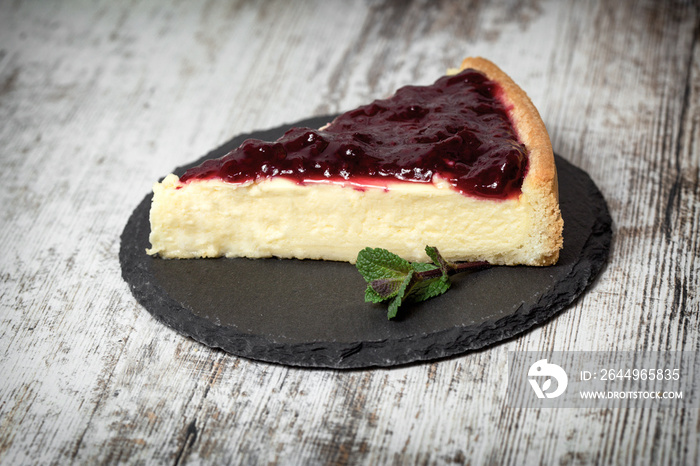 Slice of cheesecake topped with blackberry jam