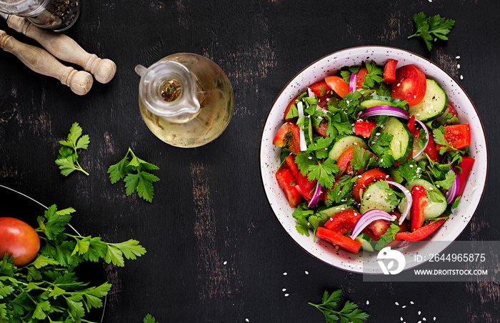 Tomato and cucumber salad with red onion, paprika, black pepper and parsley. Vegan food. Diet menu. Top view. Flat lay