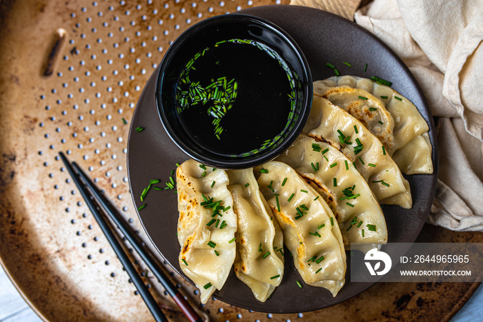 Homemade fried Asian potsticker dumpling appetizer. Gyzo Asian Pork Potstickers with Soy Sauce. Dumplings on a plate.