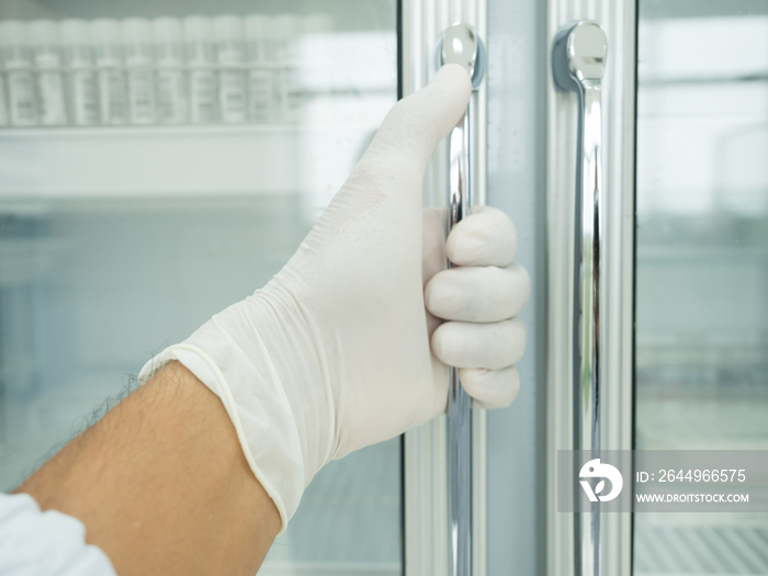 Close up scientist hand opening storage reagent container for laboratory analysis.Laboratory concept.