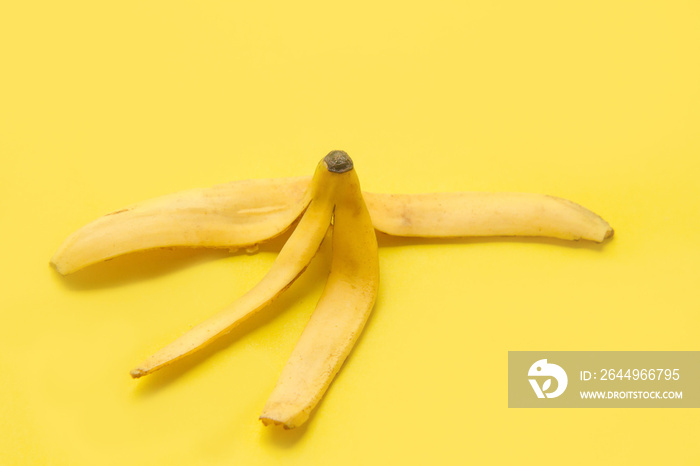 Banana peel on yellow background