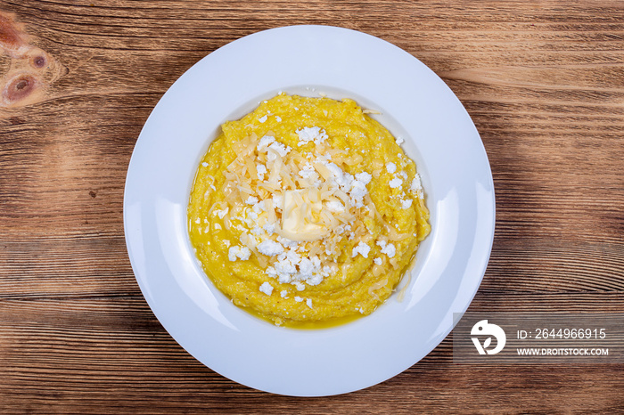 Kulesha - Hutsul corn porridge, cooked on water, served with cheese, butter, cheese and sour cream on the plate, Western Ukraine