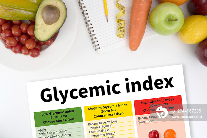 Glycemic index Fitness and weight loss concept, dumbbells, white scale, fruit and tape measure on a wooden table, top view