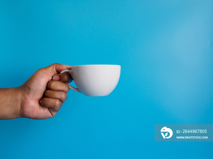 Man hand holding a white coffee cup, filled with hot black coffee(americano), no sugar no milk, ready to drink, refreshing. aroma awake fresh to work placed on a blue isolated background