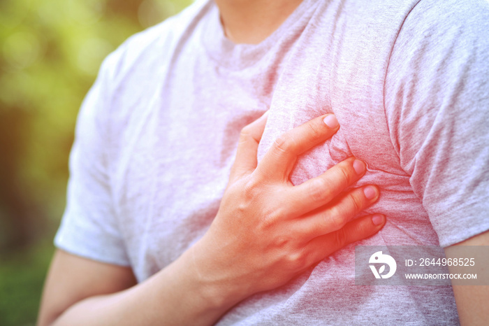 Man having chest pain - heart attack outdoors. or Heavy exercise causes the body to shock heart disease. red circle emphasizes pain. Health concept.