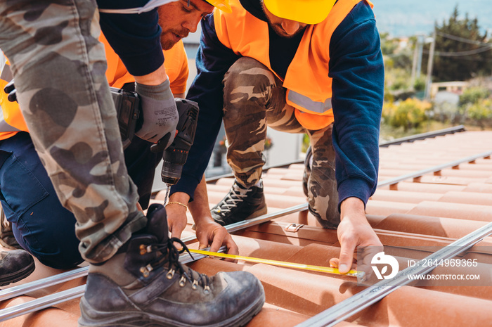 Team of technical workers work on the roof of a house