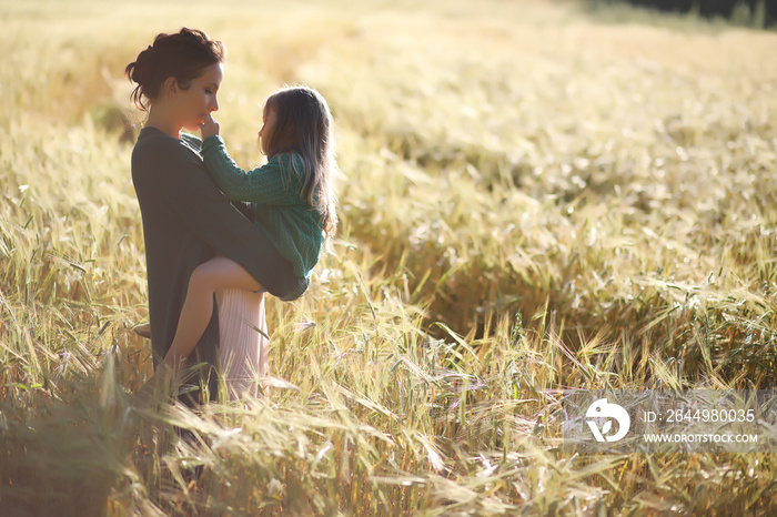 A young mother walk in wheat fields