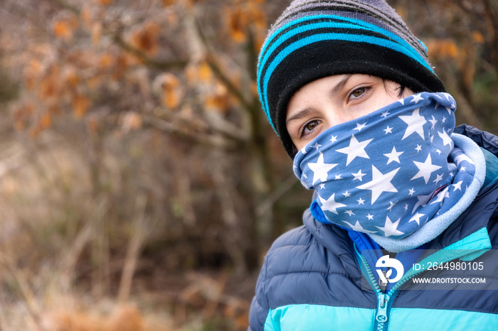 Boy with face protection against weather or viruses in covid pandemic