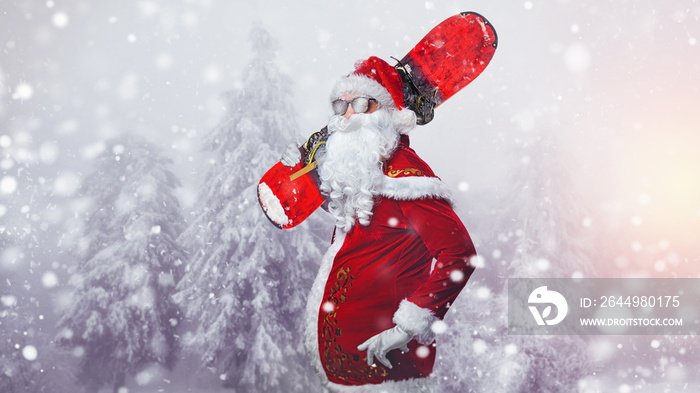 serious santa claus in ski mask standing with snowboard in snow-covered mountains - happy New Year