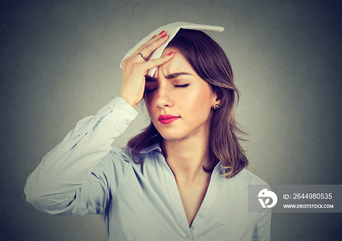 woman wipes sweat from her forehead with a handkerchief