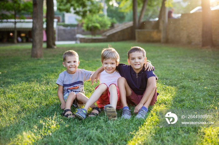 Three happy young boys in summer park