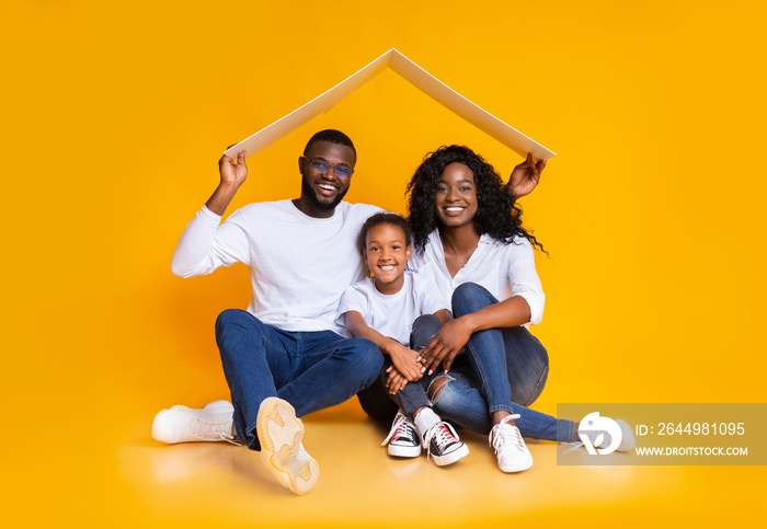 Afro Family Sitting Under Symbolic Roof Thinking About New Home.