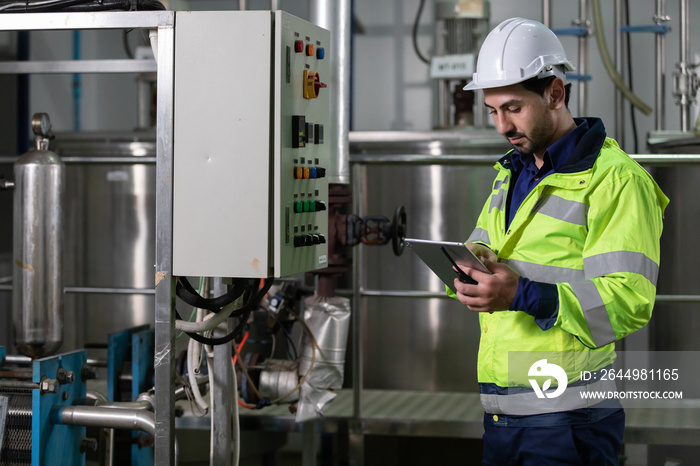 engineer or factory worker using tablet computer for finding how to use machine control panel in factory