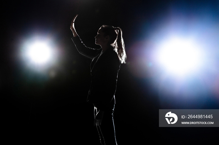 Silhouette of sad woman posing isolated on dark background.