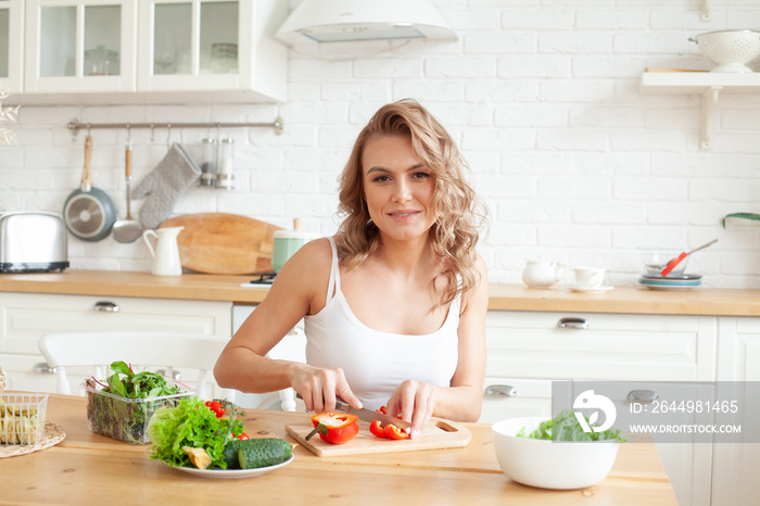 Fit blonde woman preparing vegetable. Healthy lifestyle and healthy eating concept