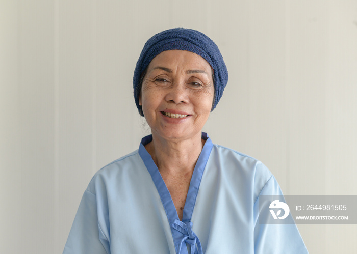 Portrait of senior cancer patient woman wearing head scarf in hospital, healthcare and medical concept