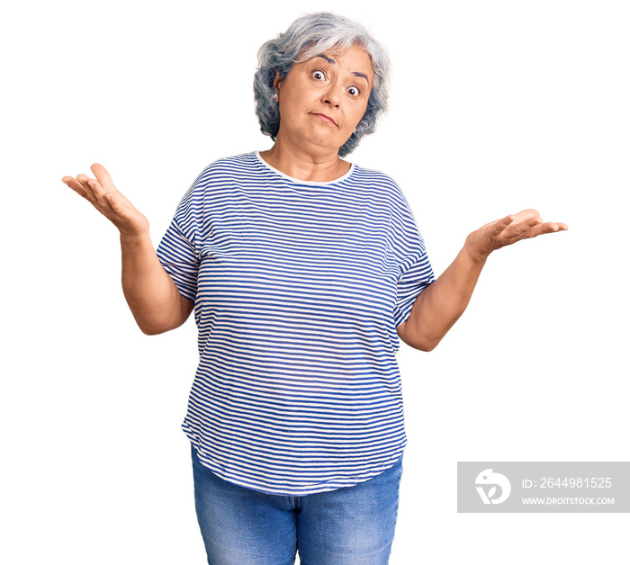 Senior woman with gray hair wearing casual striped clothes clueless and confused expression with arms and hands raised. doubt concept.