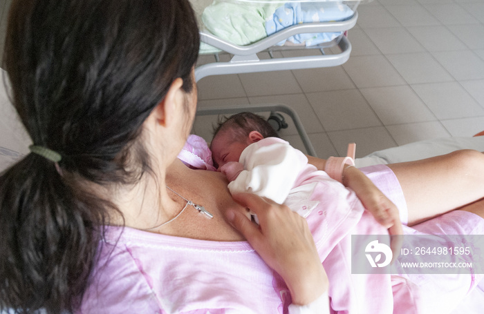 Mother breastfeeding her baby in hospital room. Healthy lifestyle concept