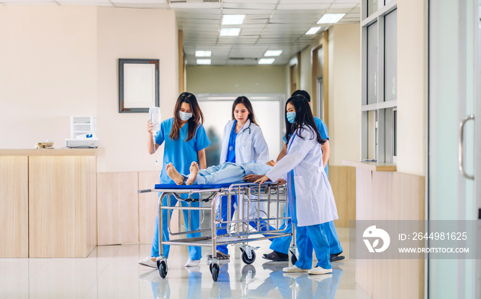 Group of professional medical doctor team and assistant with stethoscope in uniform taking seriously injured patient to operation emergency theatre room in hospital.health medical care concept