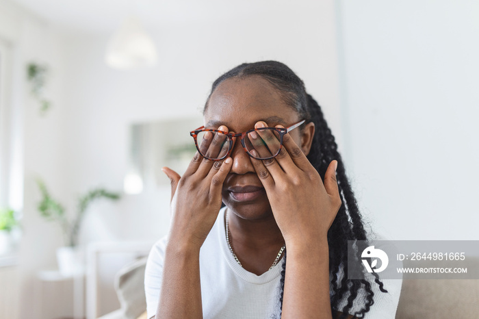 African girl in glasses rubs her eyes, suffering from tired eyes, ocular diseases concept