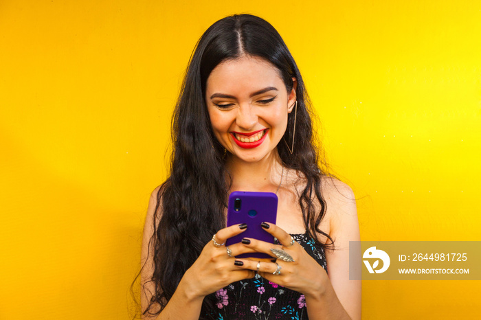 Woman talking on her cell phone on a yellow wall