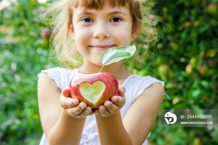 Child with an apple. Selective focus. Garden.