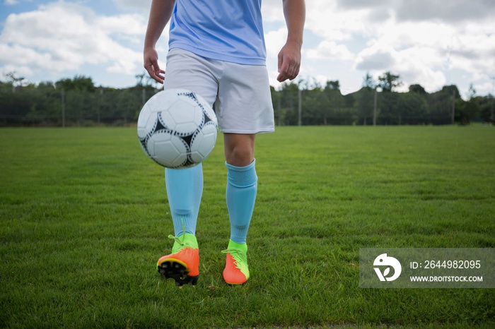 Football player juggling soccer ball