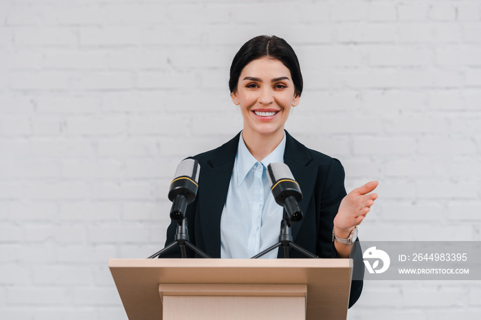 happy speaker gesturing and smiling near microphones