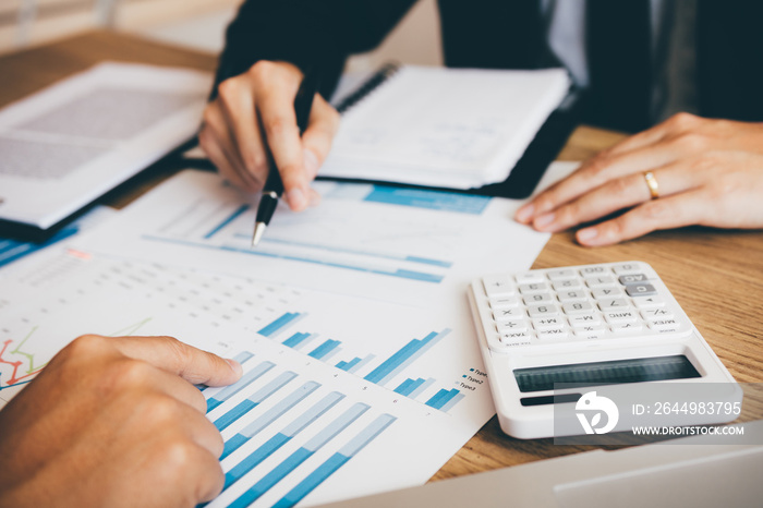 The accounting staff of the company are jointly analyzing the graph of the expenses on the desk in the office.