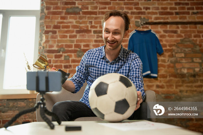 Winner emotions. Happy man, soccer fan recording vlog about last football match and shares his opinion on the strategy of the game. Sport, hobby and leisure concept.