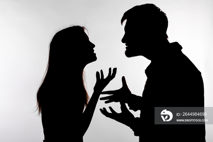 Aggression and abuse concept - man and woman expressing domestic violence in studio silhouette isolated on white background.