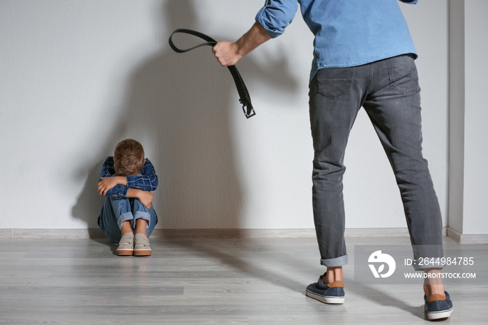 Man threatening his little son at home. Physical punishment concept