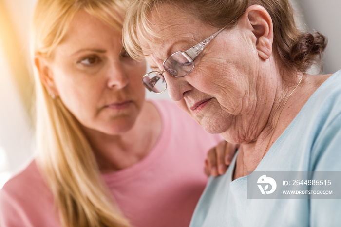 Young Adult Woman Consoles Sad Senior Adult Female