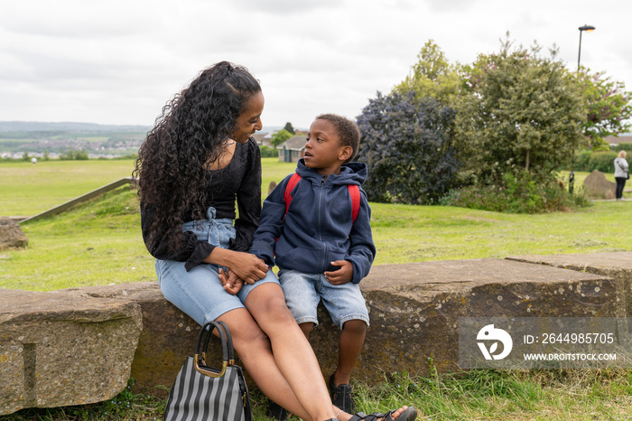 Mother and son sitting on stone wall