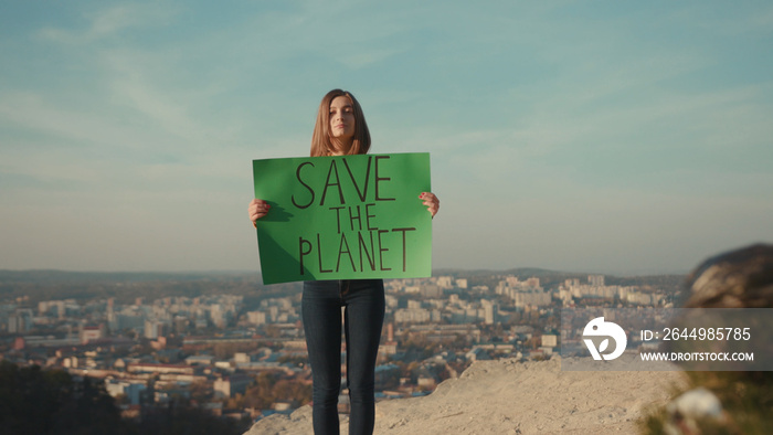 Young woman activist holding encouraging green poster Save the Planet standing around plastic bag background beautiful view nature environmental community earth eco outdoor recycle trash waste