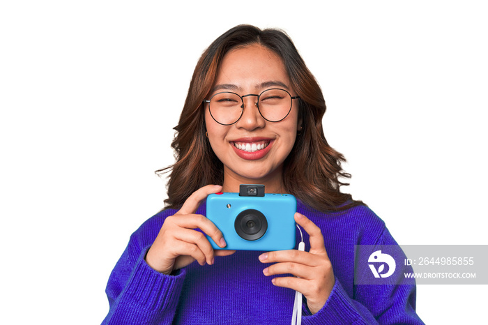 Happy Asian woman holding a retro camera.