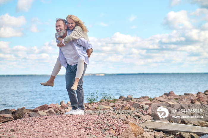 Man holding smiling woman on his back